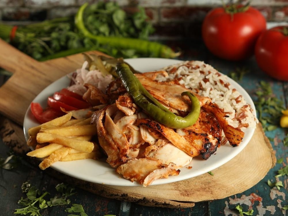Döner-Teller mit Hähnchenfleisch vom Spieß, Pommes, Reis, Tomaten und gegrillter Peperoni